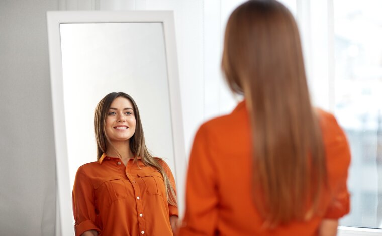 Lady happy with her appearance in the mirror